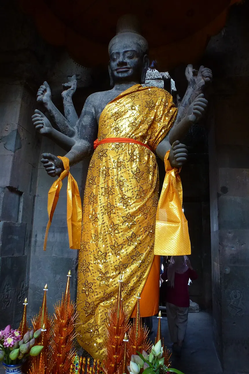 Tượng Vishnu tám tay ở cổng phía tây Angkor Wat, Campuchia, nay được khoác vải vàng và dâng lễ. Ảnh chụp năm 2014.
