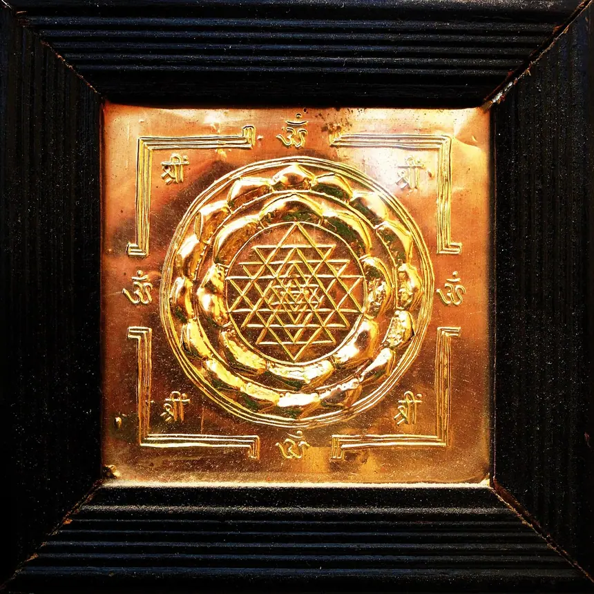 Sri Yantra chạm trên một tấm đồng, khoảng năm 1980: chín hình tam giác đan nhau quanh một điểm ở giữa. Đồ mới, không phải cổ vật.