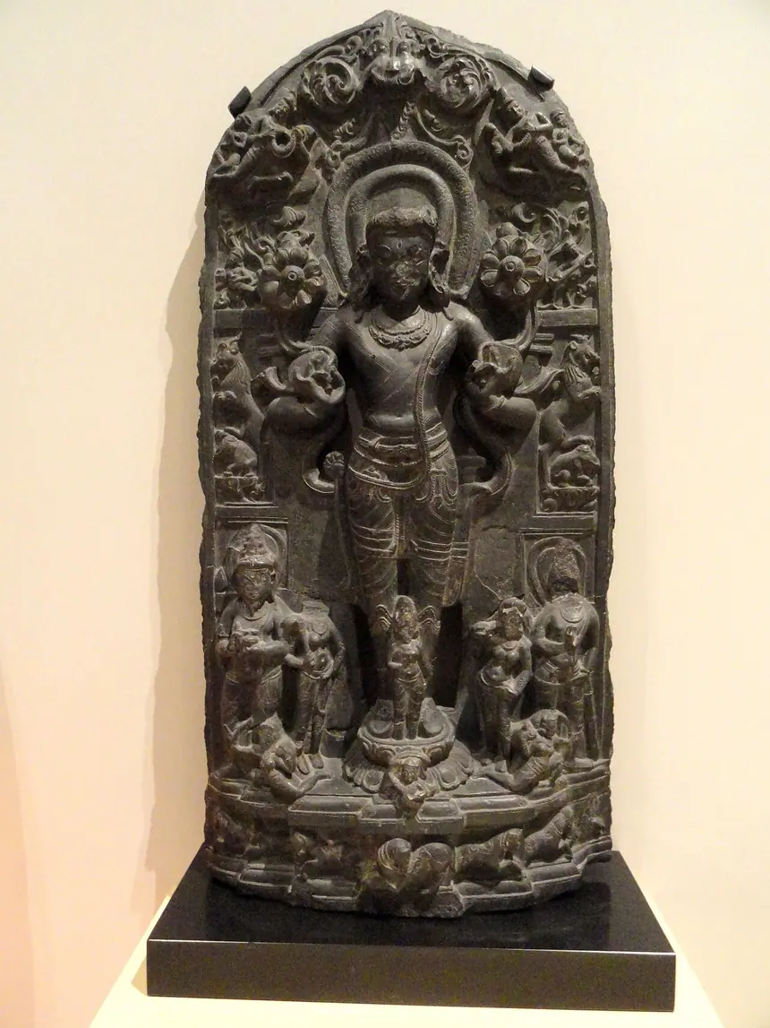 Thần mặt trời Surya đứng, hai tay cầm hai đóa sen nở. Đá, đông bắc Ấn Độ, thời Pala, thế kỷ 11. Bảo tàng Hoàng gia Ontario, Toronto.