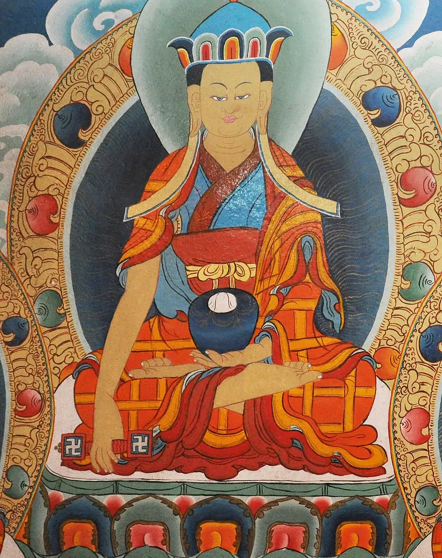 Tonpa Shenrab đội mũ hoa sen, mặc y vá nhiều mảnh, tay trái đỡ bát, tay phải cầm cây trượng yungdrung. Tranh tường mới, ảnh chụp ngày 11 tháng 5 năm 2013. Trang tệp gốc không ghi nơi vẽ, cùng ngày tác giả có đăng ảnh tu viện Bön ở Kewzing, Sikkim.