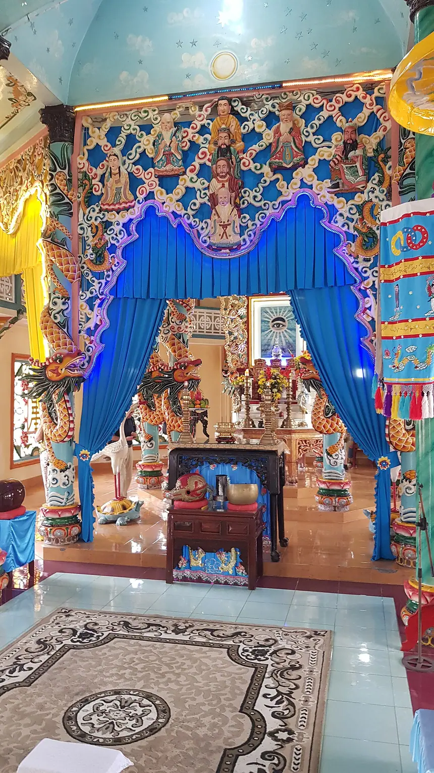 Bên trong Thánh thất Cái Bè: bao lam đắp tượng các Đấng ở trên, phía trong là Thánh Tượng Thiên Nhãn đóng khung. Ảnh chụp năm 2025.