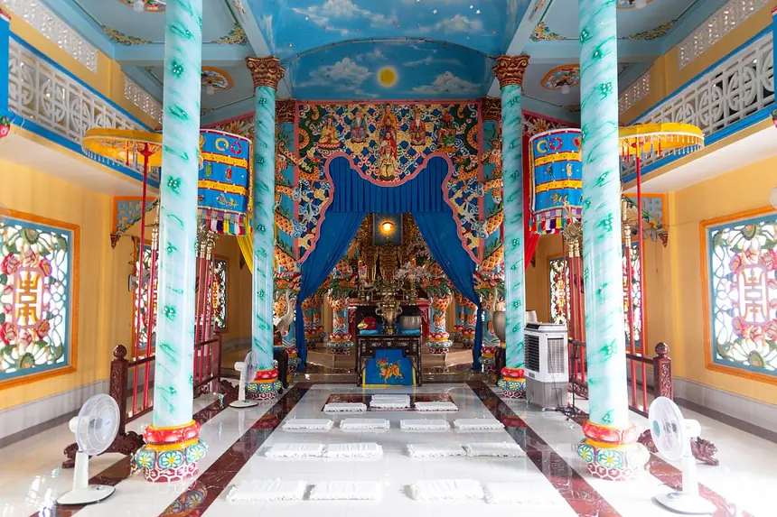 Bên trong Thánh thất Sài Gòn: bao lam đắp tượng các Đấng, màn xanh và Thiên Bàn phía trong. Ảnh chụp năm 2024.