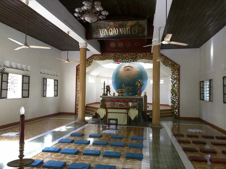 Bên trong Trung Hưng Bửu Tòa, Đà Nẵng, của Hội thánh Truyền giáo Cao Đài: Quả Càn Khôn có Thiên Nhãn ở cuối điện, phía trên là bảng chữ Vạn Giáo Nhất Lý. Ảnh chụp năm 2015.