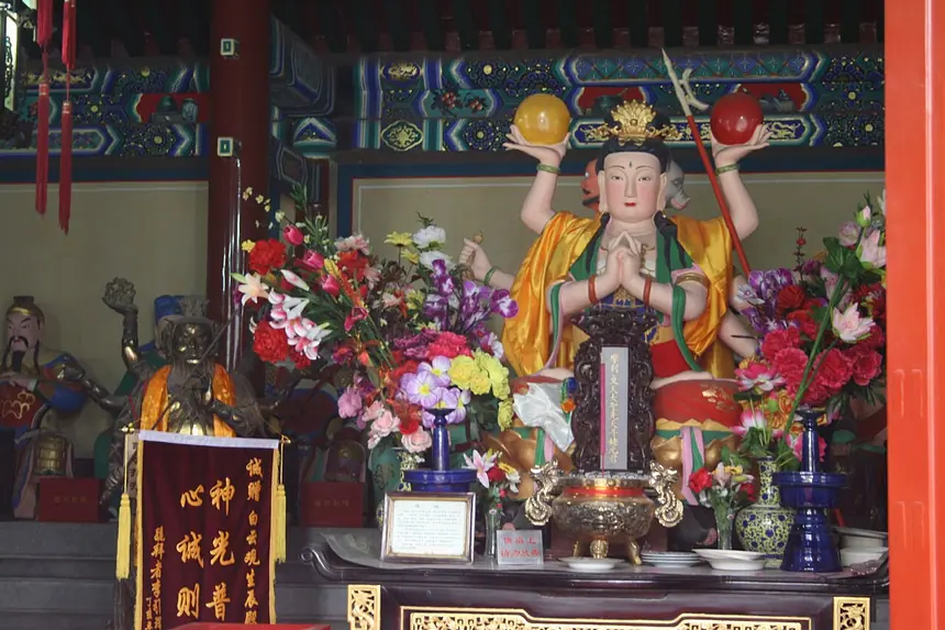 Tượng Đẩu Mẫu nhiều tay, hai tay trên cùng nâng hai vầng tròn, trên một ban thờ ở Bạch Vân quán, Bắc Kinh. Ảnh chụp năm 2007.