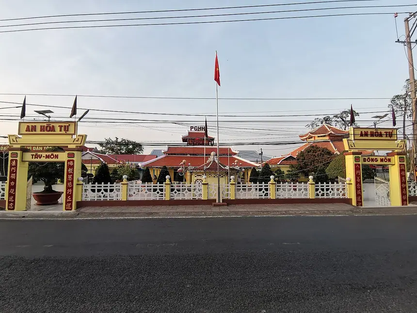 An Hòa Tự, Tổ đình của Phật giáo Hòa Hảo ở Phú Tân, An Giang, nhìn từ ngoài đường: hai cổng Tây Môn và Đông Môn, phía sau là mái chùa. Ảnh chụp năm 2026.