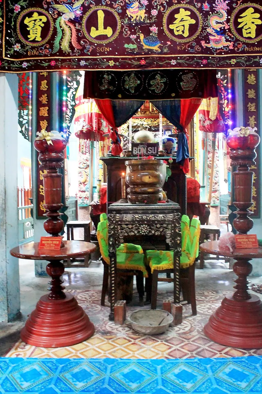 Nơi thờ Đức Bổn Sư Ngô Lợi trong chùa Tam Bửu, Ba Chúc: một chiếc ghế để trống, không có tượng hay ảnh, phía trên là bức màn thêu bốn chữ Hán Bửu Sơn Kỳ Hương. Ảnh chụp năm 2014.