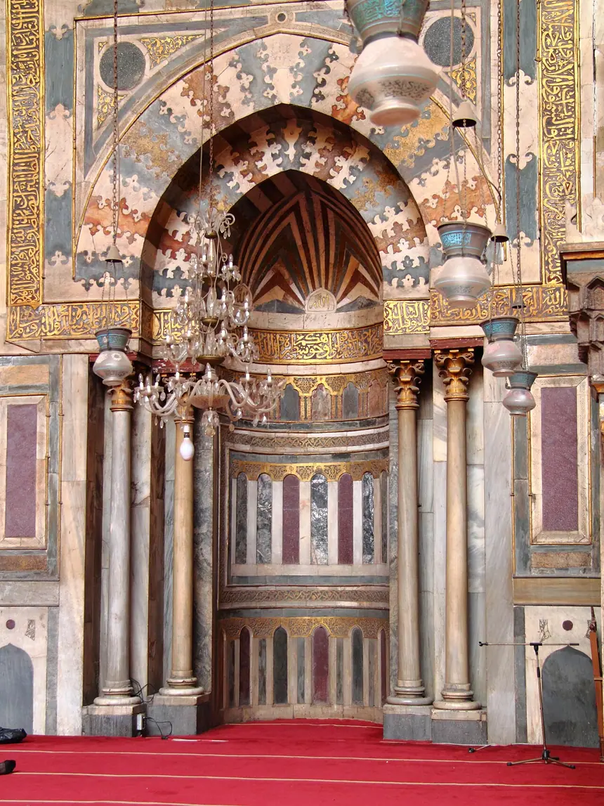 Mihrab ốp đá hoa nhiều màu và các ngọn đèn treo trong thánh đường kiêm trường học Sultan Hasan, Cairo, Ai Cập, năm 1356 tới 1363, thời Mamluk.
