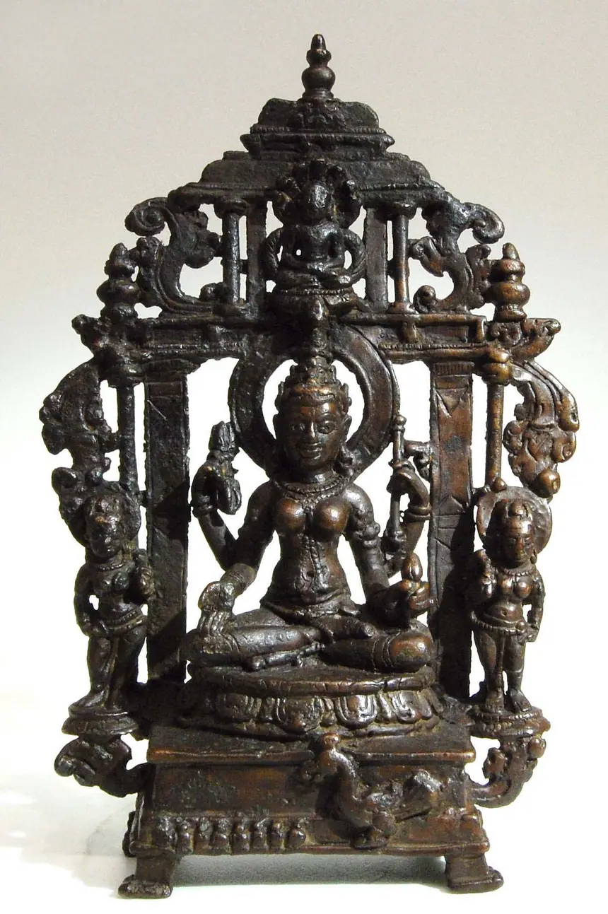 Một nữ thần hộ trì bốn tay ngồi trên tòa, phía trên có vị Jina nhỏ. Đồng, Gujarat, khoảng thế kỷ 10. Trang ảnh trên Wikimedia Commons ghi là Padmavati. Bảo tàng Metropolitan, New York.