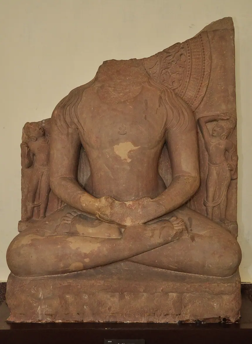 Rishabhanatha ngồi thiền, sa thạch, khoảng thế kỷ 5, tìm thấy ở gò Kankali, Mathura. Đầu tượng đã mất, lọn tóc còn trên vai. Bảo tàng Mathura.