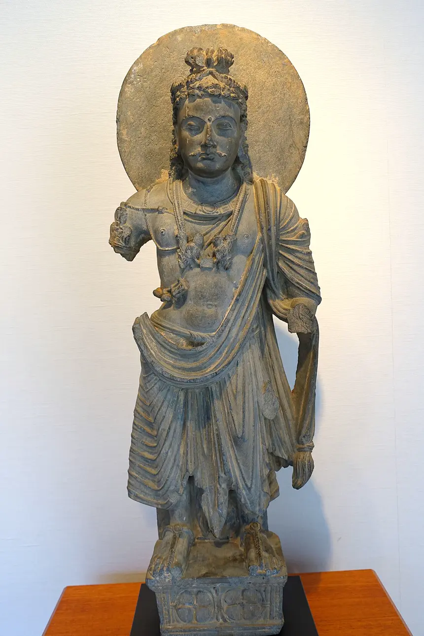 Bồ tát Di Lặc đứng, đá phiến xám, Gandhara, khoảng thế kỷ 3. Bảo tàng Mỹ thuật Matsuoka, Tokyo.