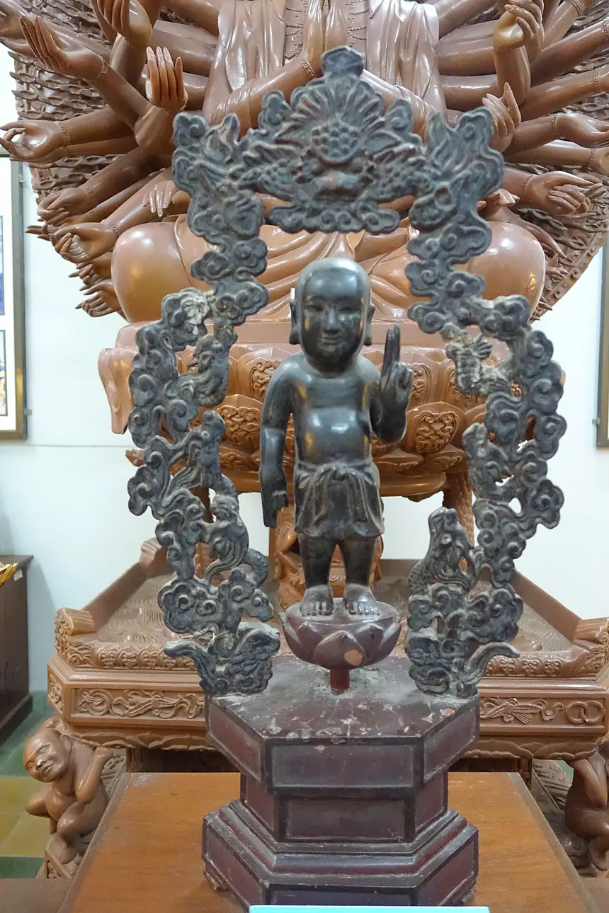 Thích Ca sơ sinh đứng giữa vòng rồng, kiểu Tòa Cửu Long, Việt Nam, thế kỷ 19. Bảo tàng Lịch sử Thành phố Hồ Chí Minh.