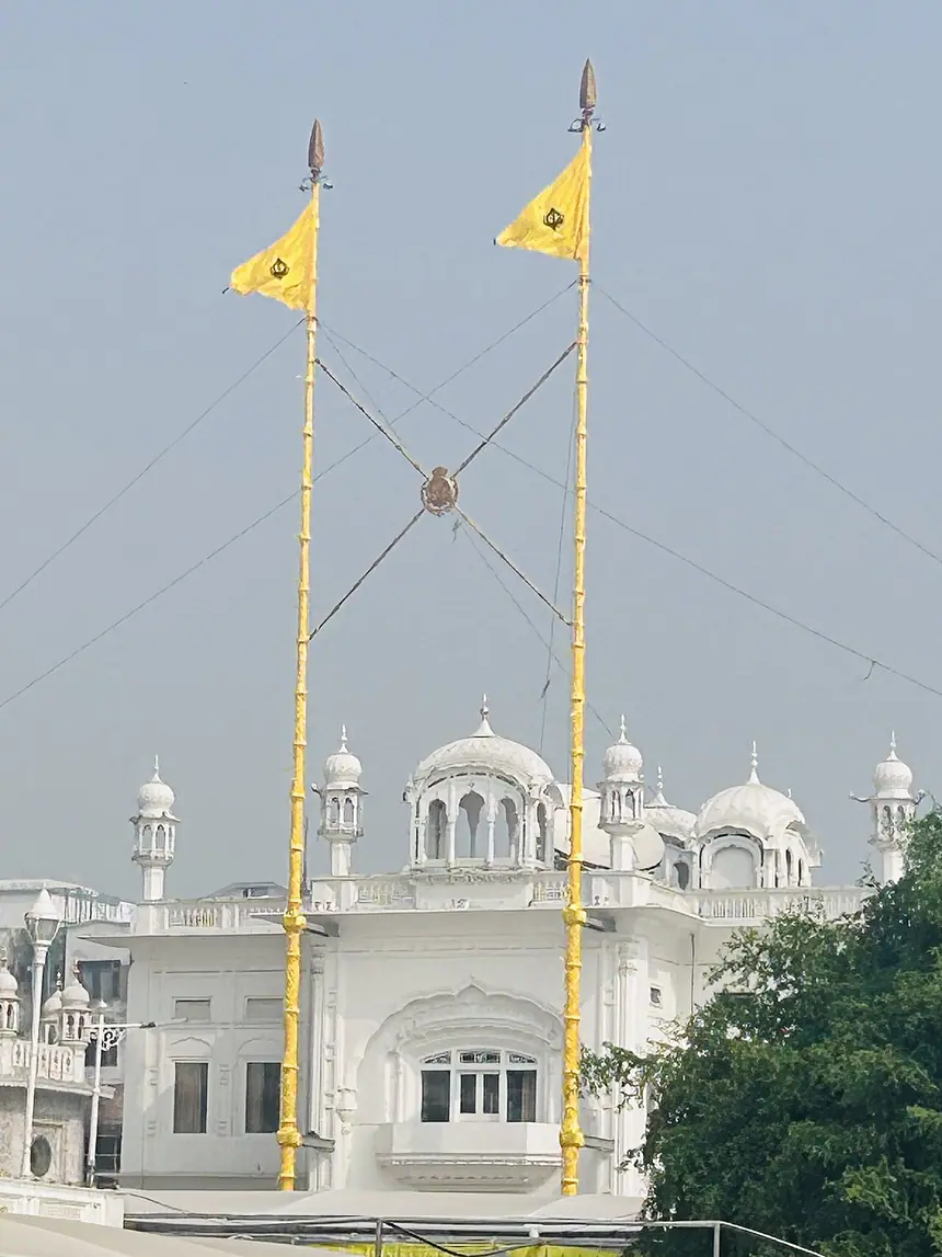 Hai cột cờ Nishan Sahib song đôi gần Akal Takht trong quần thể Đền Vàng, Amritsar, tượng trưng cho Miri và Piri. Cột cờ bọc vải cùng màu với cờ. Ảnh chụp năm 2024.