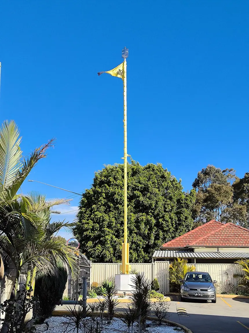 Cột cờ Nishan Sahib trước Gurudwara Sri Guru Singh Sabha ở Revesby, Úc. Thấy cột cờ này là biết nơi đó có gurdwara. Ảnh chụp năm 2024.