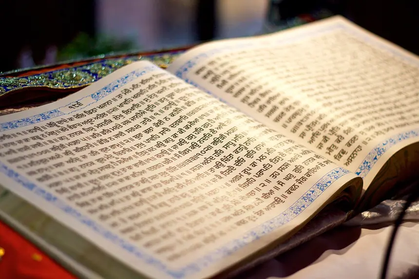 Một trang Guru Granth Sahib đang mở, chữ Gurmukhi. Bản in hiện nay. Ảnh chụp năm 2016.
