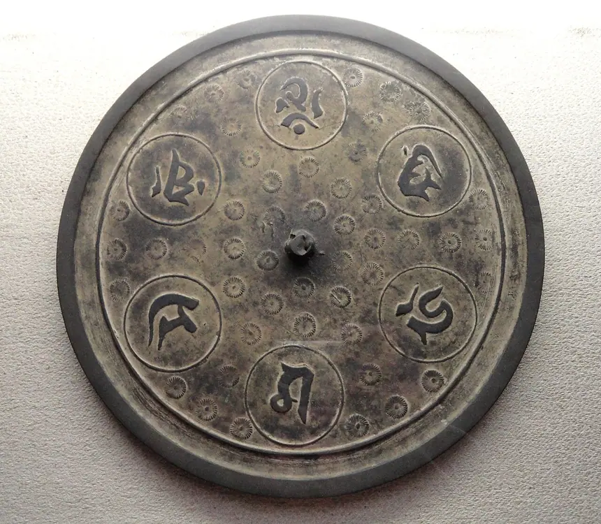 Gương thần (shinkyō) có chữ Phạn và hoa cúc, trưng bày ở Bảo vật quán đền Itsukushima. Chữ Phạn là loại chữ dùng trong Phật giáo.