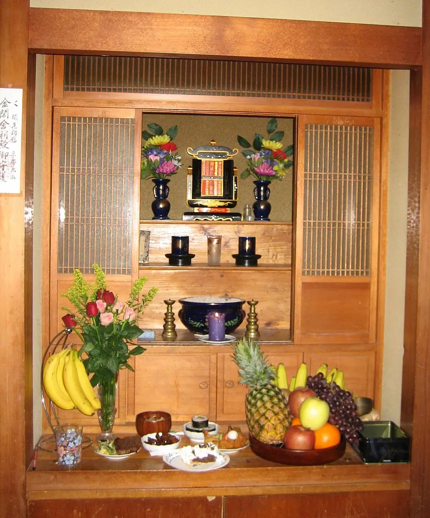 Bàn thờ trong một nhà ở Naha, Okinawa. Hàng trên cùng là các thẻ ghi tên người đã mất, bên dưới là nước, trà, bát hương và hoa quả.