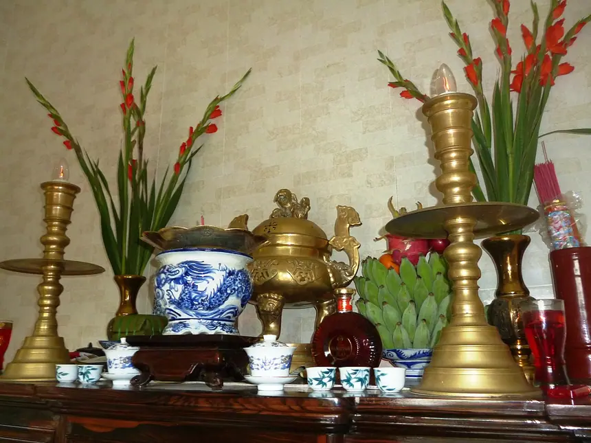 Bộ tam sự trên một bàn thờ đang dùng: chiếc lư ở giữa, hai chân đèn hai bên. Ảnh chụp năm 2015.