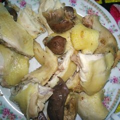 Whole boiled young rooster with crossed wings holding a red rose