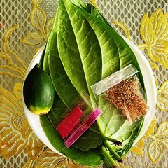 Plate of three or five fresh betel leaves with green areca nuts